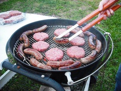 Cooking patties and sausages on the grill