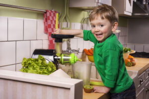 a boy making green juice