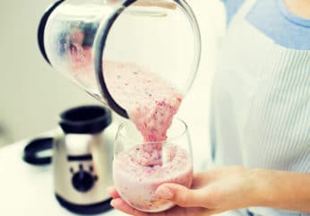 close-up of woman with blender and shake at home