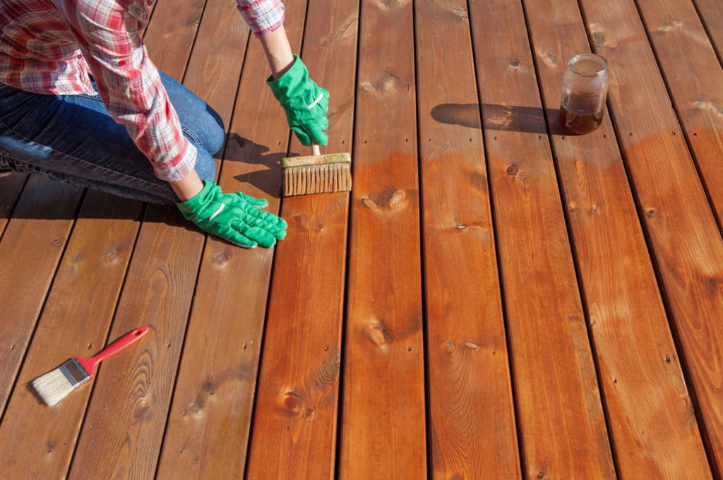 woman varnishing the wooden deck