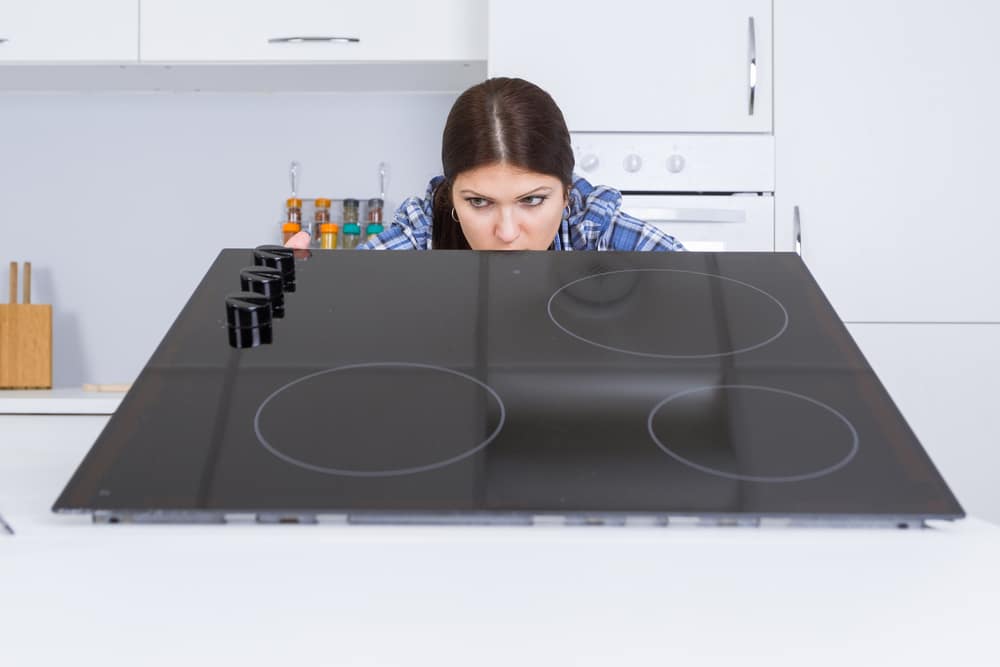 a woman fixing the kitchen equipment